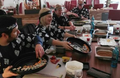 Die Gruppe präsentiert die selbstgemachten Sushi-Kreationen