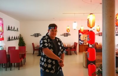 Japanisches Ambiente mit Lampen, Dekoration und roten Stühlen