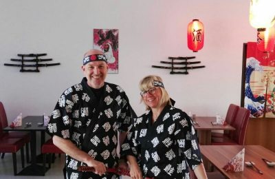 Zwei Teilnehmer mit Samurai-Schwert – gemeinsames Foto in der Bar